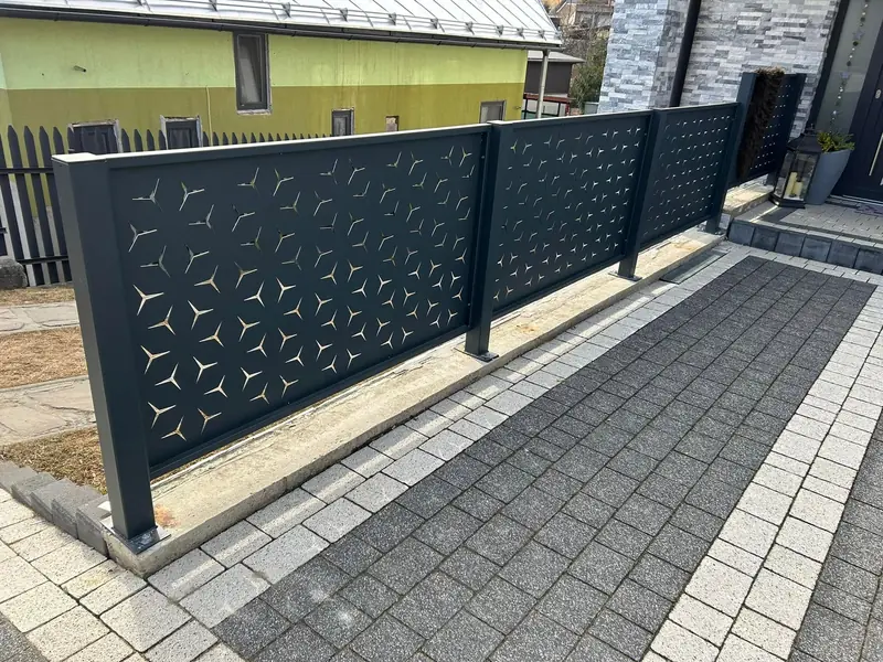 Hliníkový plot DECOR s geometrickým vzorom na hliníkových stĺpikoch a pätkách