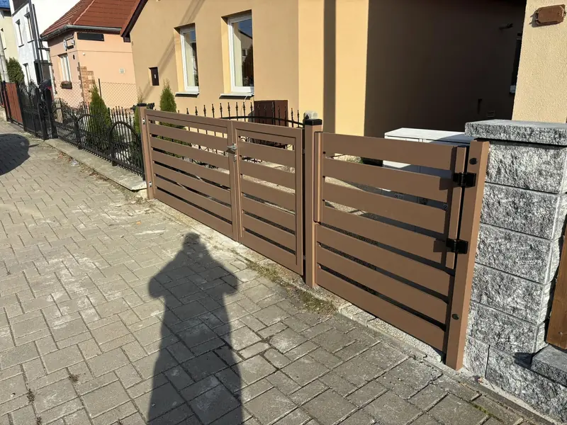 Hnedý hliníkový lamelový plot s bránkou na murovaných stĺpikoch